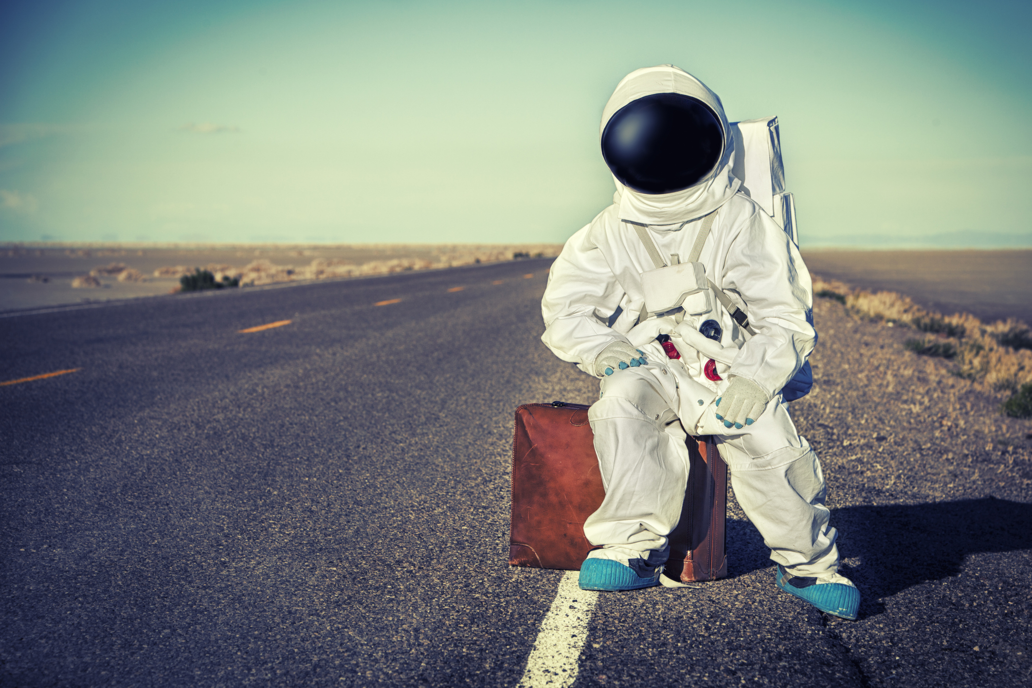 Vintage Astronaut Sitting On Luggage Waiting For A Ride